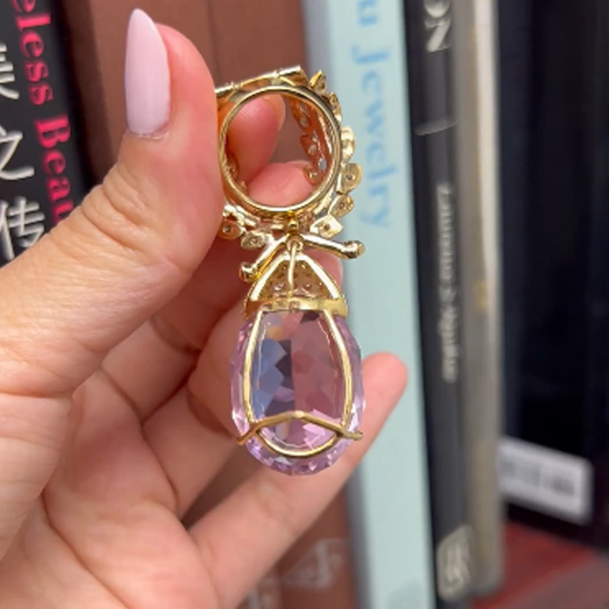 1970s 18KT Yellow Gold Diamond & Kunzite Pendant back view in hand