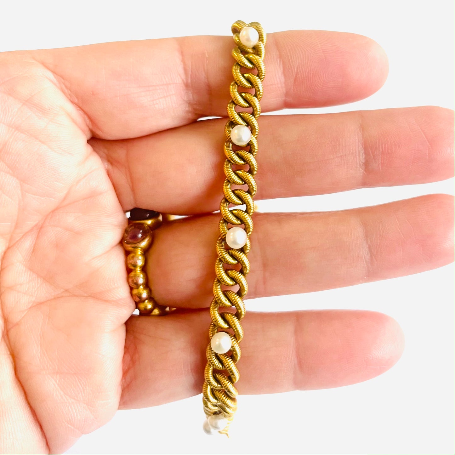 French 1930s 18KT Yellow Gold Natural Pearl Bracelet in hand