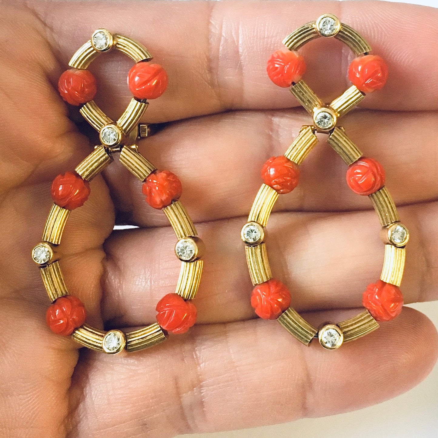 1960s 18KT Yellow Gold Coral & Diamond Earrings in hand
