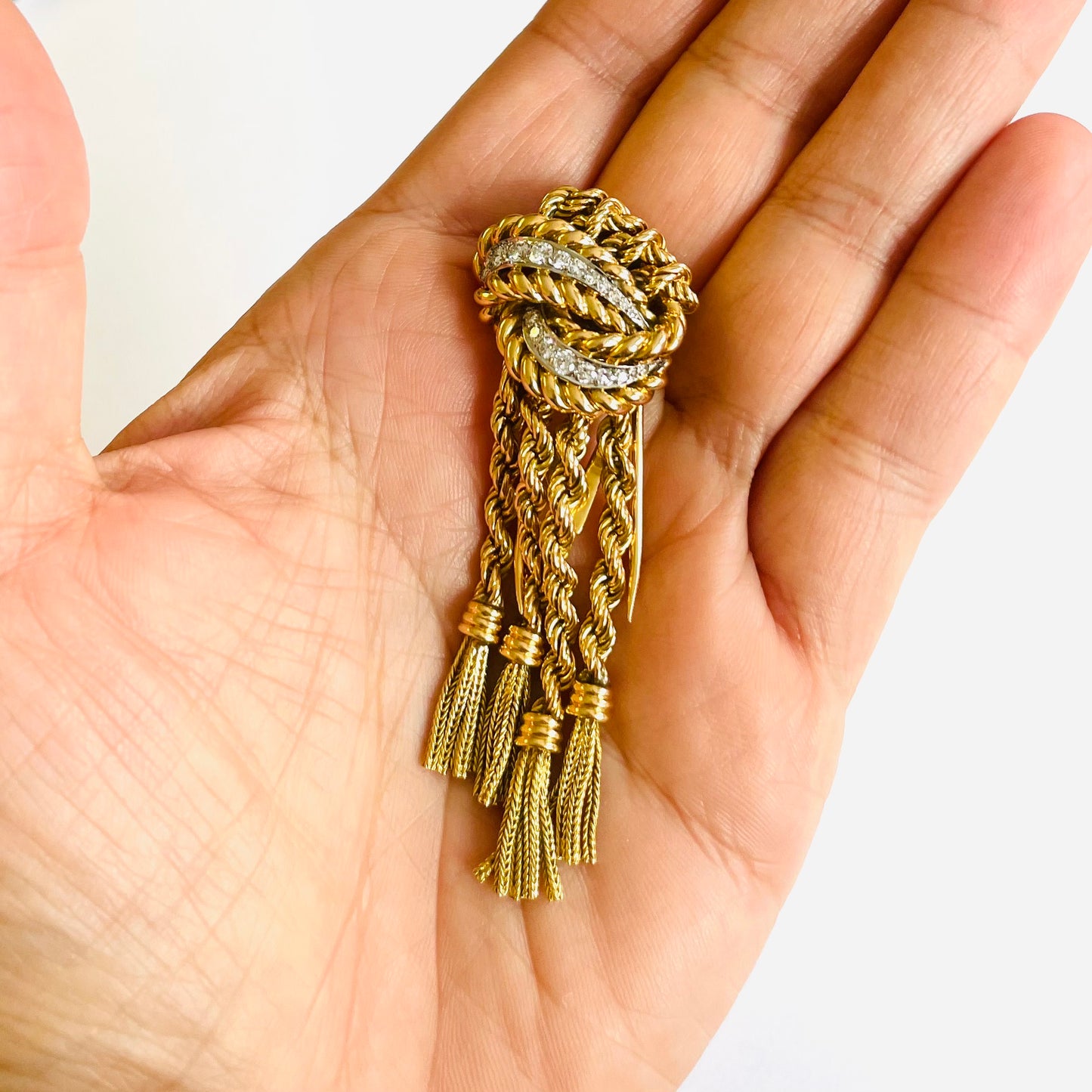 French 1940s 18KT Yellow Gold Diamond Tassel Brooch in hand
