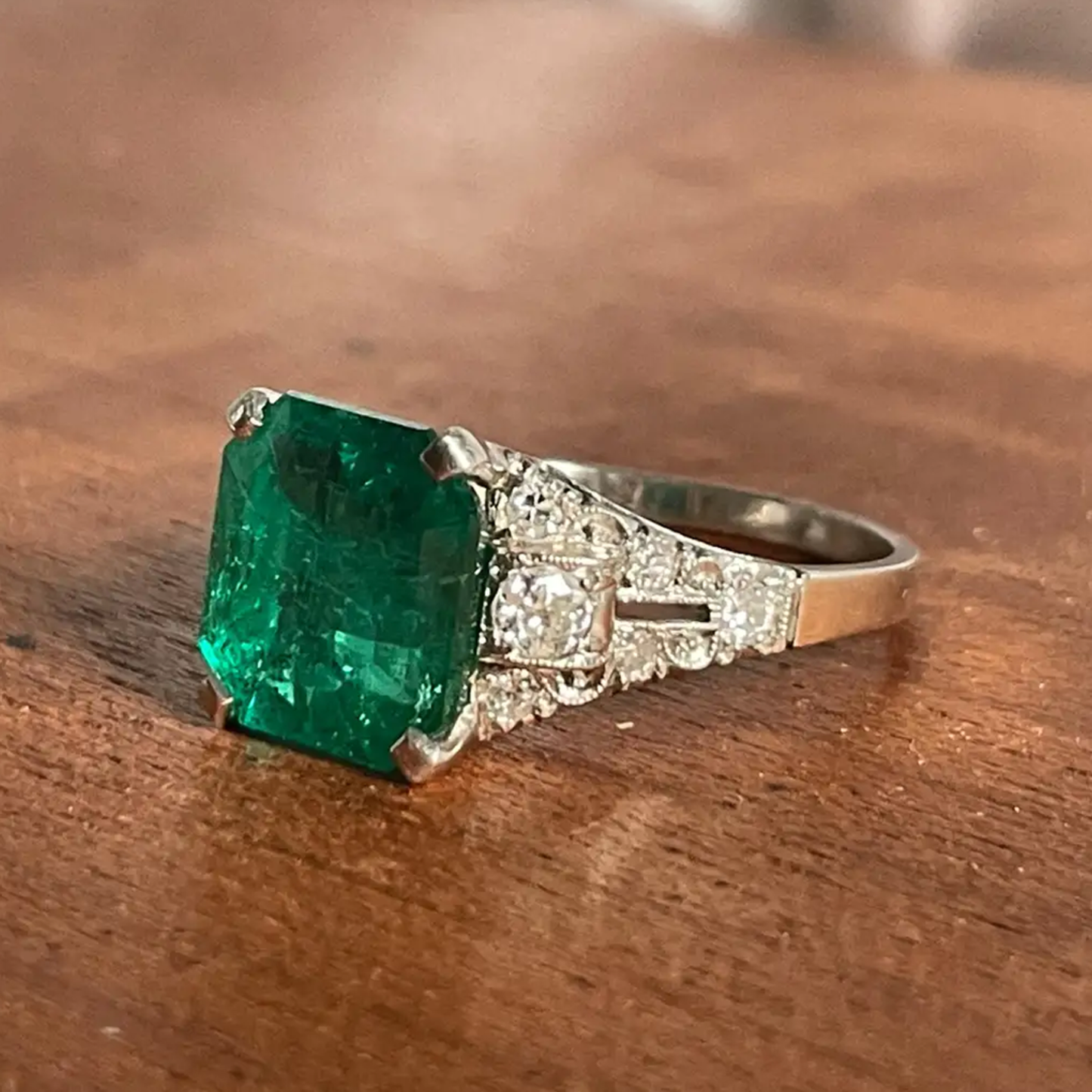 Art Deco Platinum Colombian Emerald Ring side view on desk
