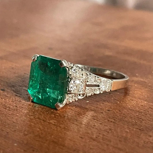 Art Deco Platinum Colombian Emerald Ring side view on desk