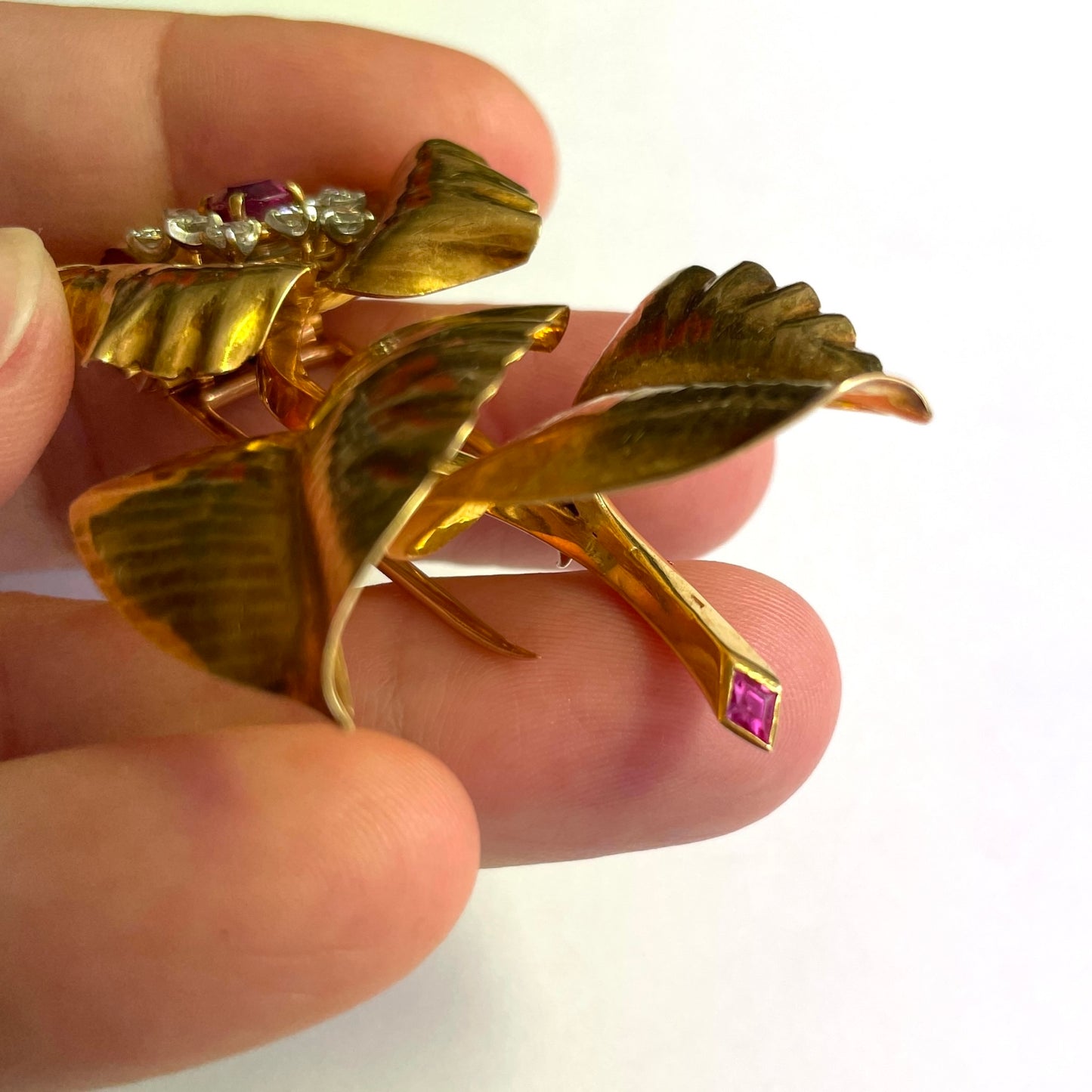 Cartier Paris 1950s Platinum & 18KT Yellow Gold Ruby & Diamond Flower Brooch in hand