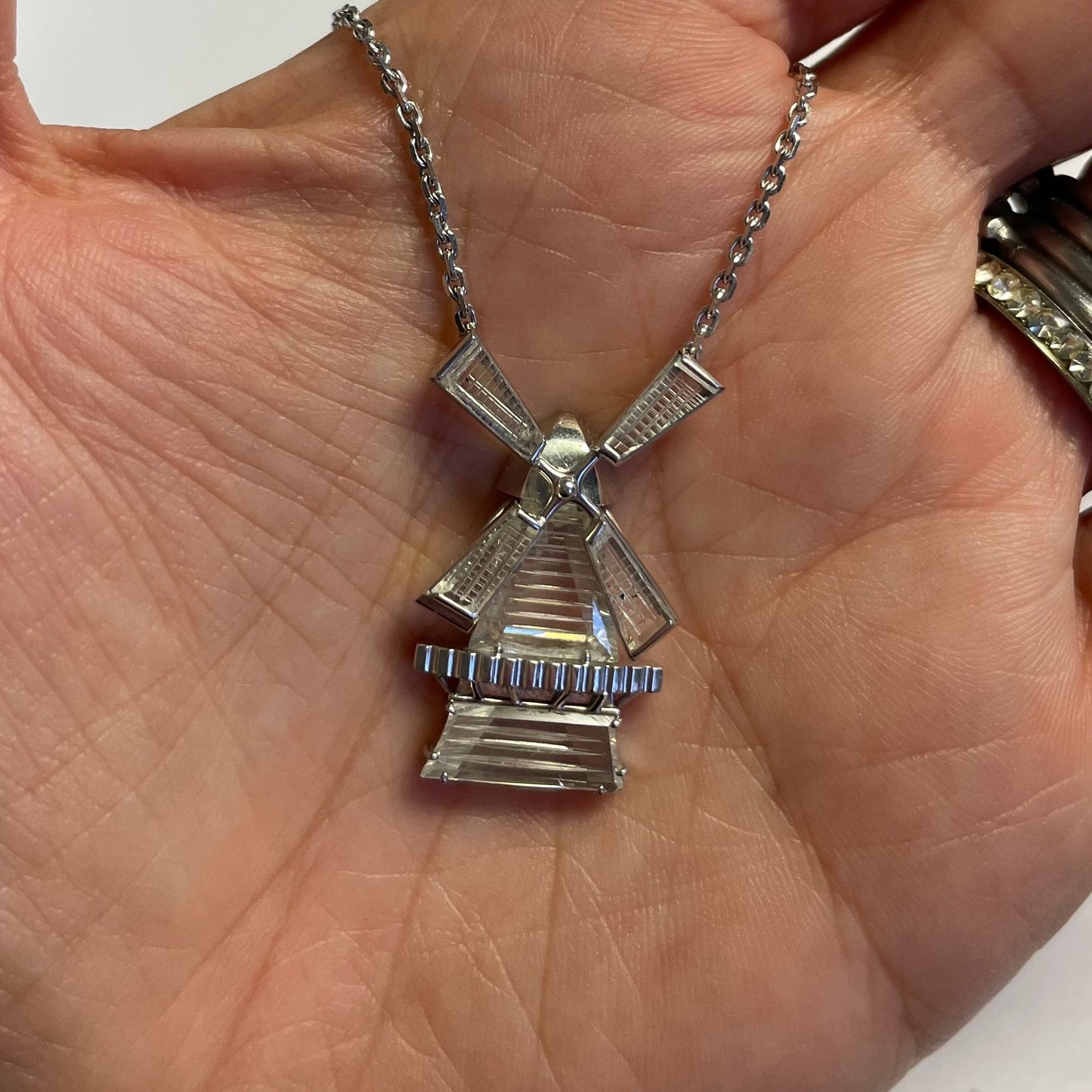 1970s Platinum Diamond Windmill Pendant in hand