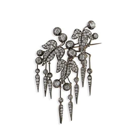 Antique silver topped gold ivy leaf themed brooch showcases old mine and rose cut diamonds.