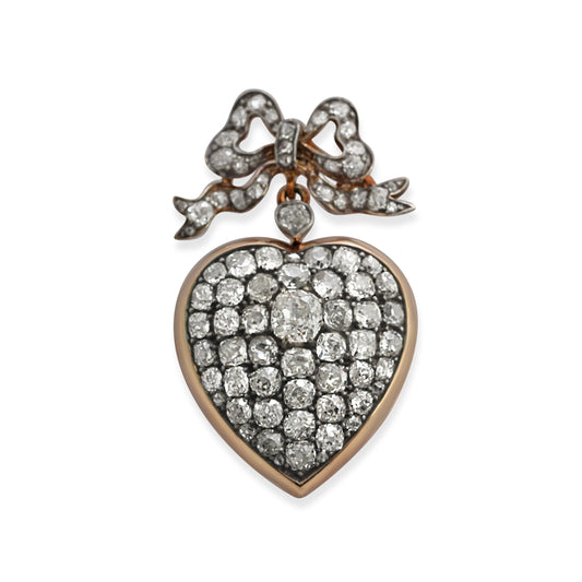 Antique diamond and silver topped gold heart and bow pendant.