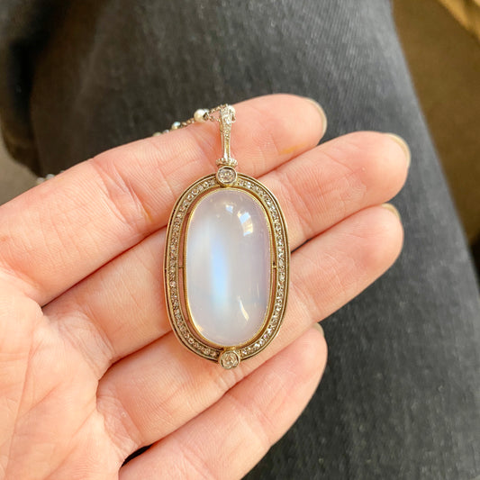 Victorian Silver & 18KT Yellow Gold Moonstone, Diamond & Natural Pearl Necklace close-up of moonstone in hand