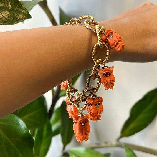 1970s 18KT Yellow Gold Carved Coral, Diamond & Ruby Charm Bracelet worn on wrist