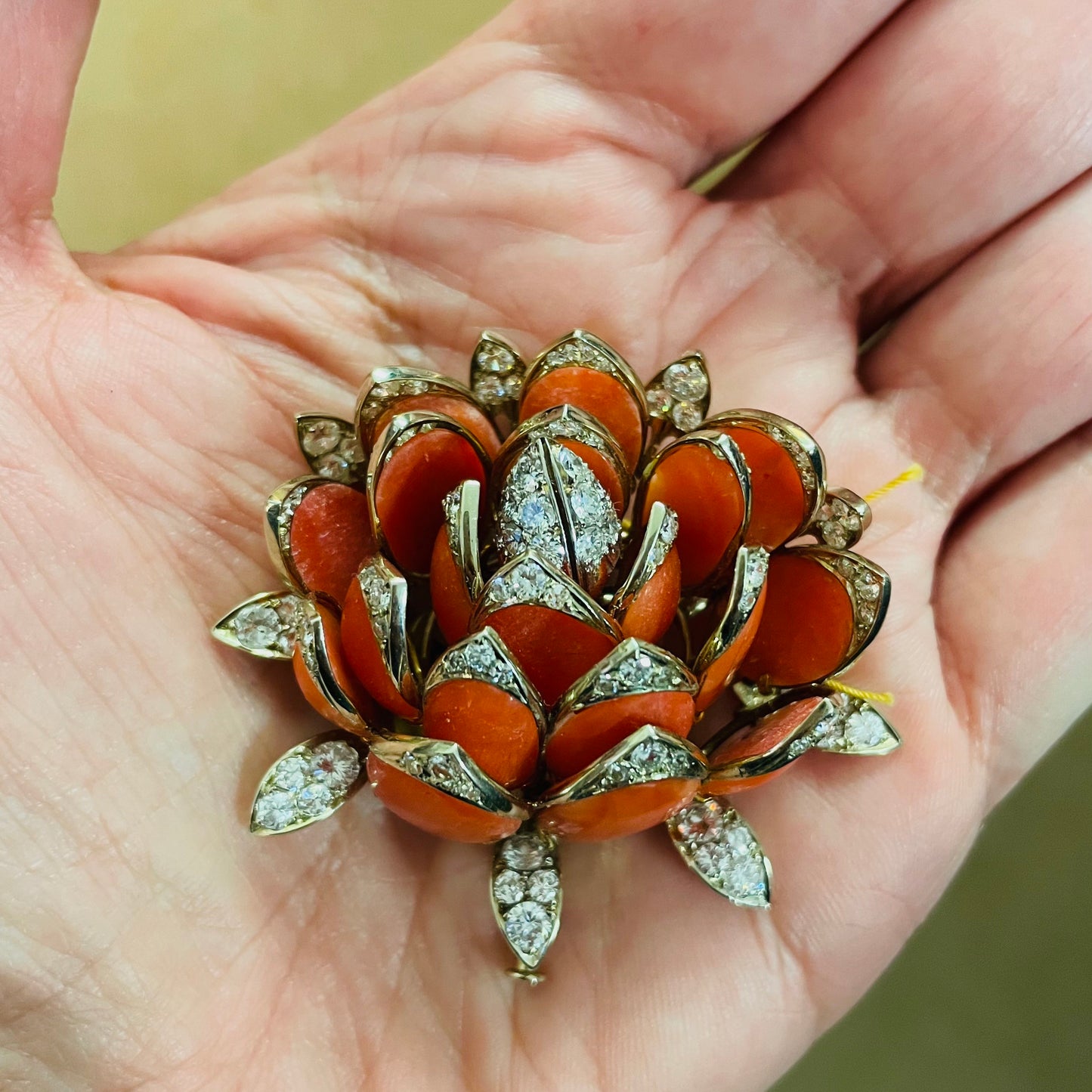 Enrico Serafini 1950s 18KT Yellow Gold Coral & Diamond Water Lily Brooch in hand