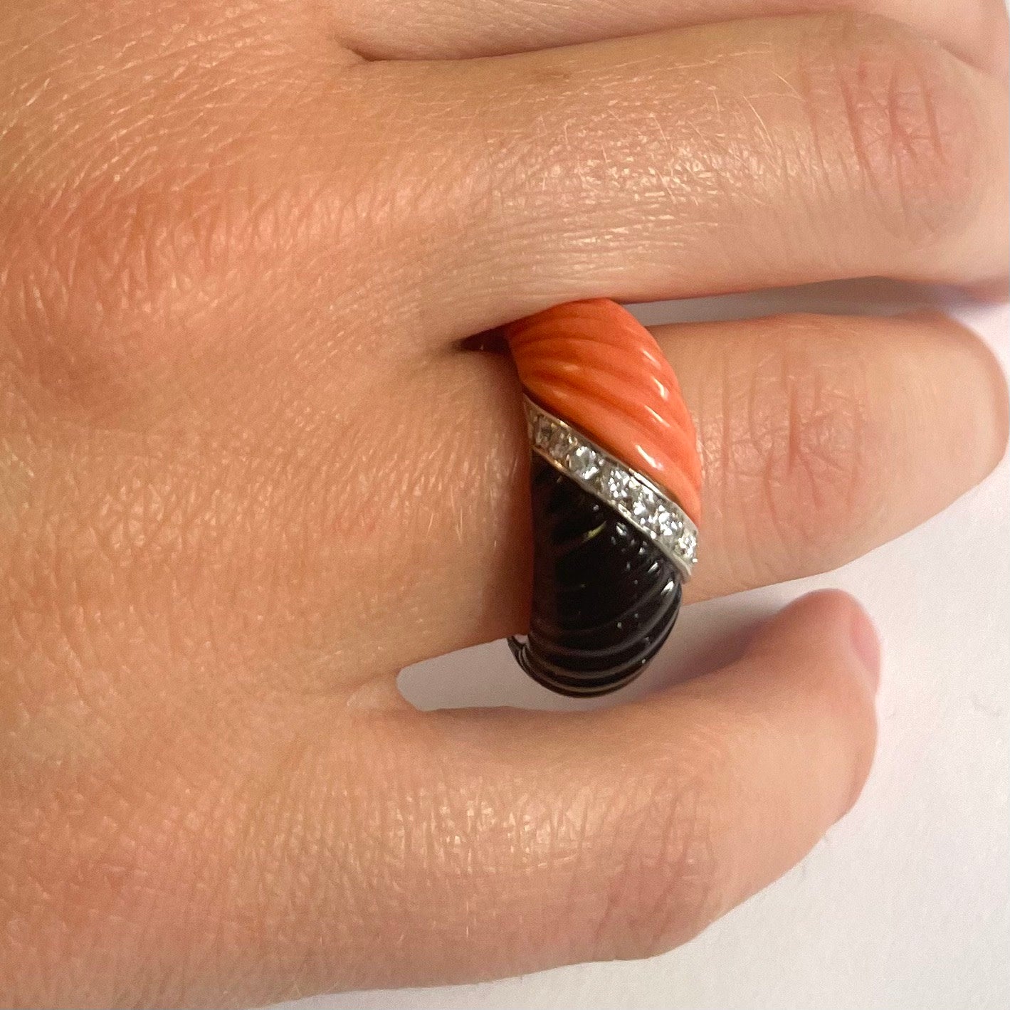 French 1970s 18KT White Gold Onyx, Coral & Diamond Ring worn on hand