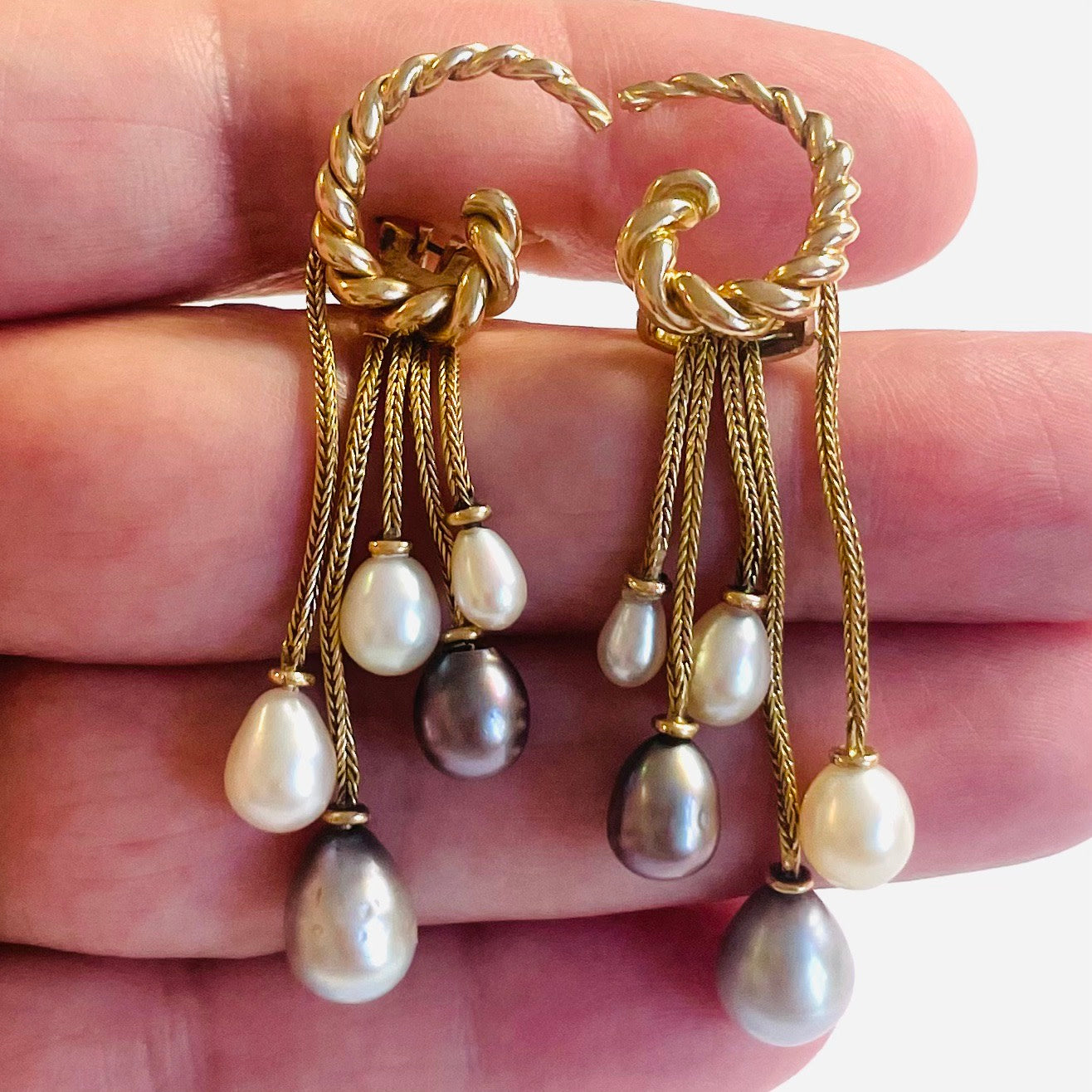 1970s 18KT Yellow Gold Natural Pearl Earrings in hand