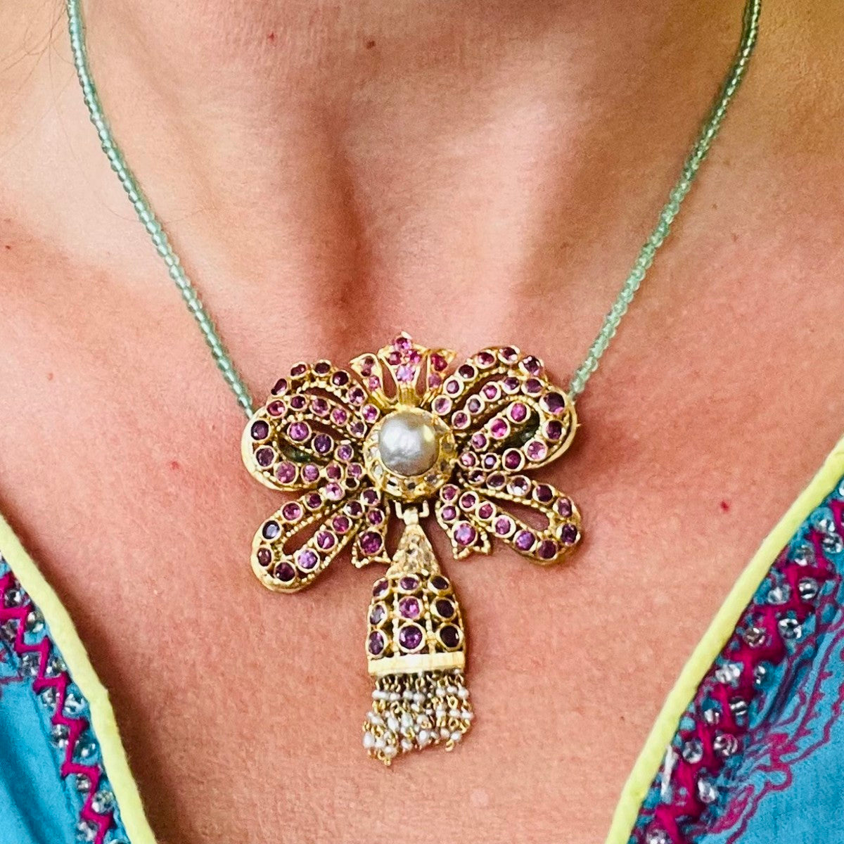 1960s 18KT Yellow Gold Ruby, Diamond & Cultured Pearl Bow Brooch worn on neck