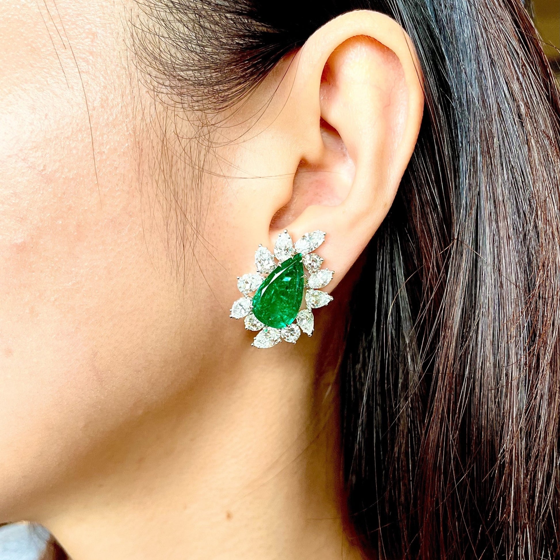 Contemporary 18KT White Gold Emerald & Diamond Earrings on ear