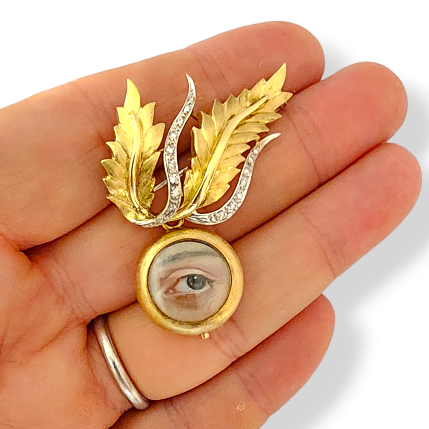 1970s 18KT Yellow Gold Diamond Lover's Eye Locket Brooch in hand