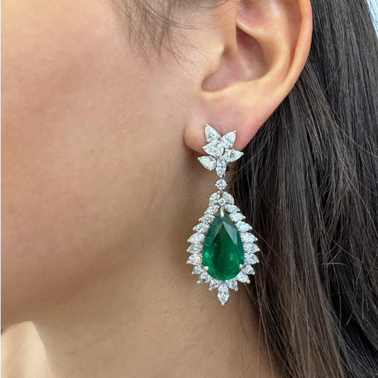 Contemporary Platinum Emerald & Diamond Earrings on ear