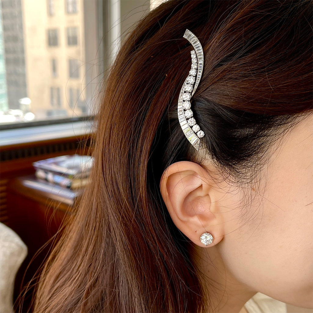 Close-up of a person wearing a decorative hair clip and earring.
