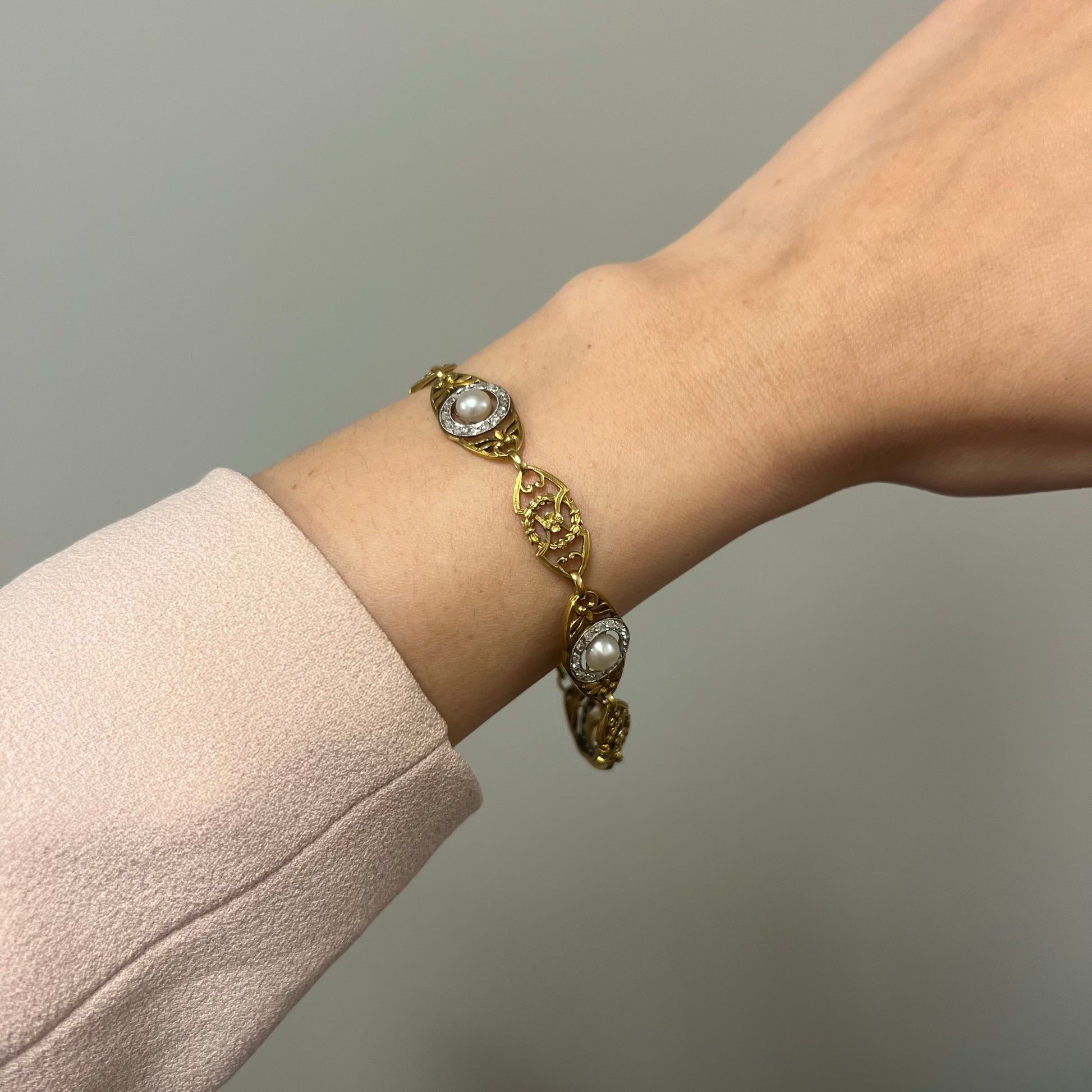 Art Nouveau 18KT Yellow Gold Diamond Natural Pearl Bracelet worn on wrist