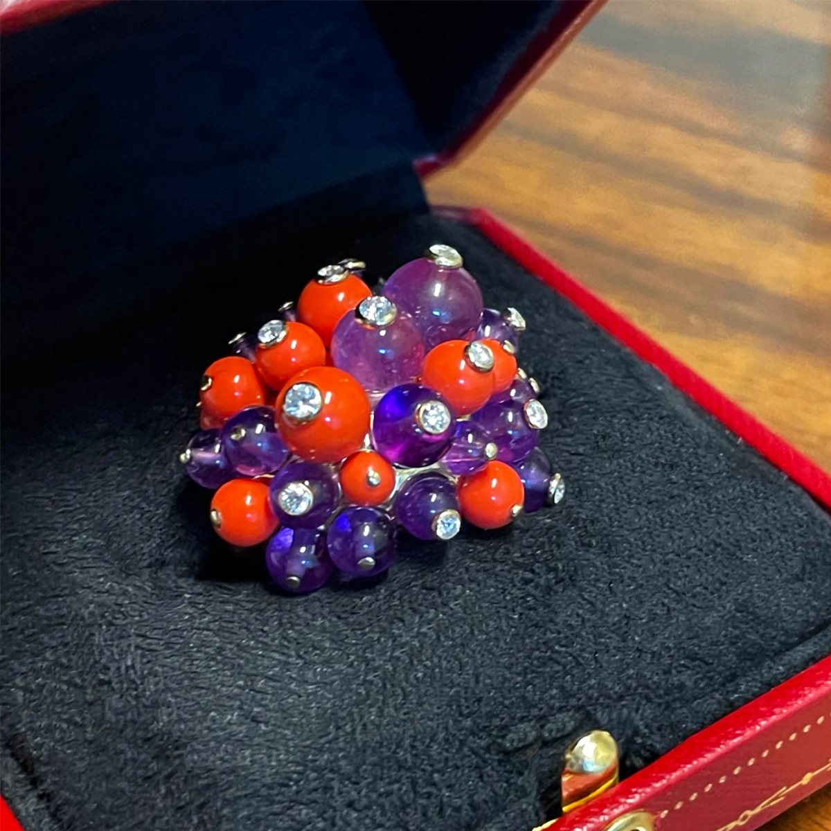 Cartier France 1970s 18KT Yellow Gold Coral, Amethyst & Diamond Pom-Pom Ring front view in jewelry box