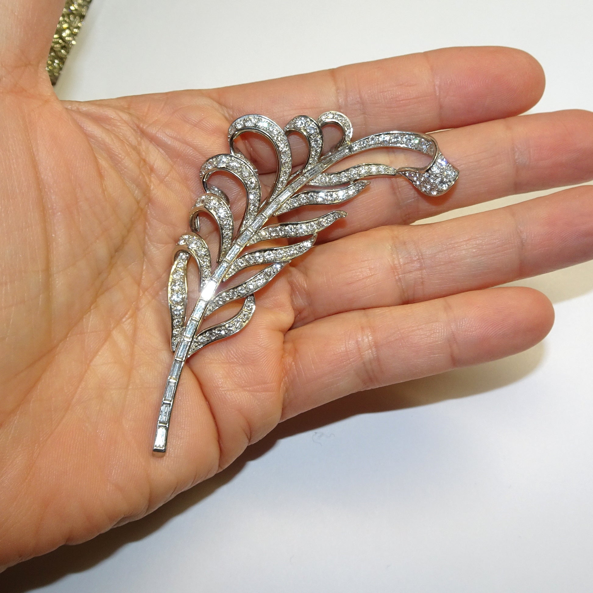 1940s Platinum Diamond Feather Brooch in hand