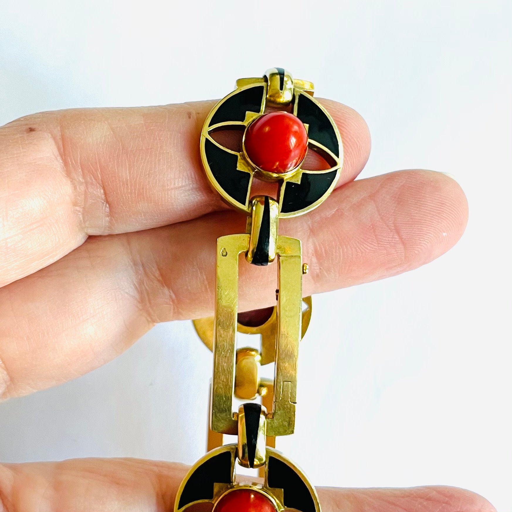 French Art Deco 18KT Yellow Gold Coral & Enamel Bracelet in hand