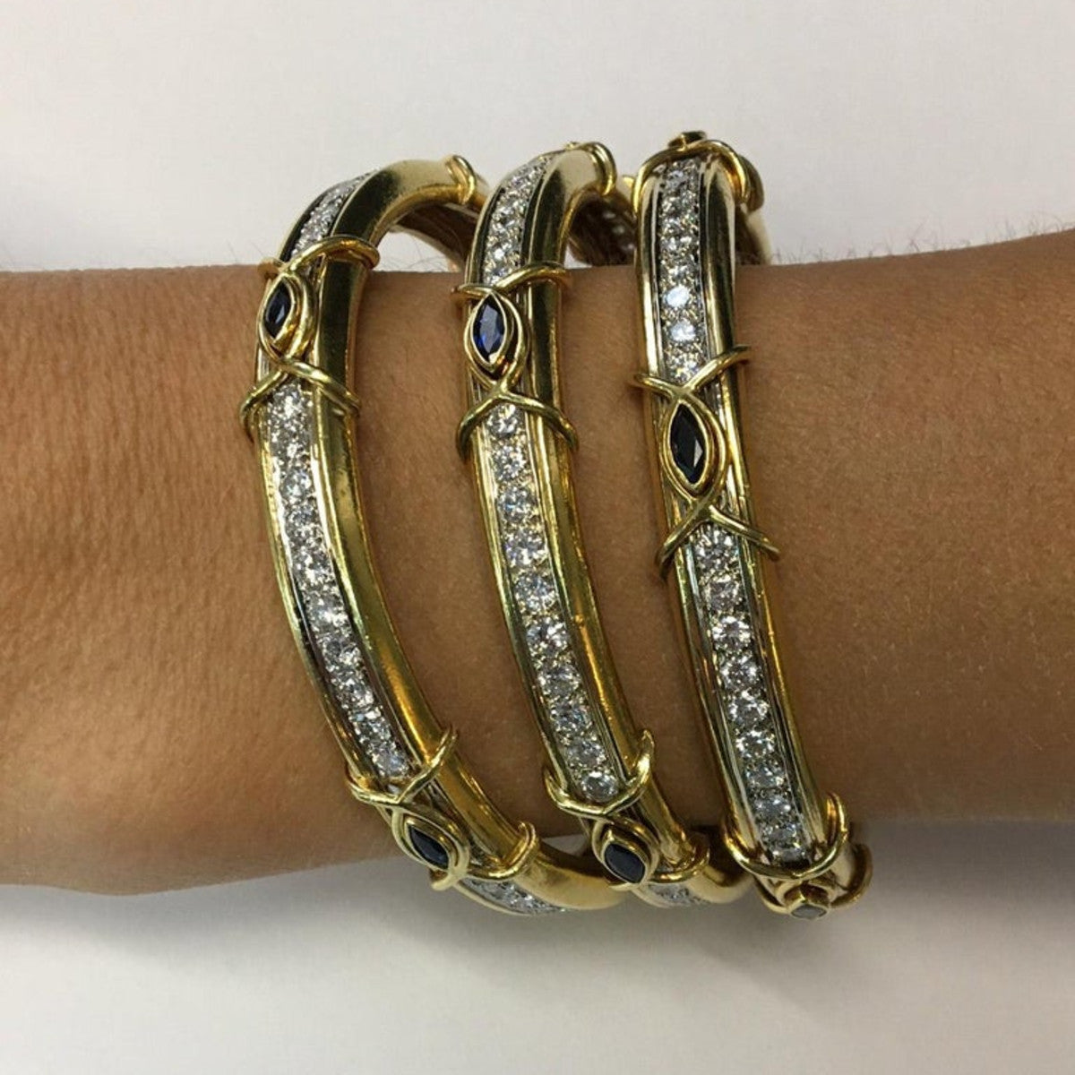 Boris Lebeau 1980s 18KT Yellow Gold Diamond & Sapphire Bangle Bracelets worn on wrist