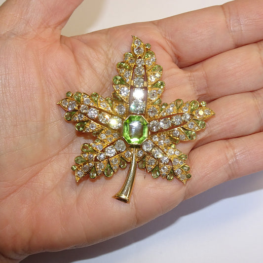 René Boivin 1940s 18KT Yellow Gold Diamond & Peridot Leaf Brooch in hand