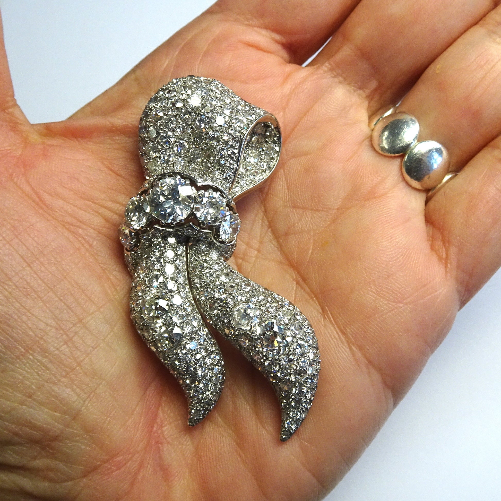 1940s Platinum Diamond Ribbon Brooch in hand