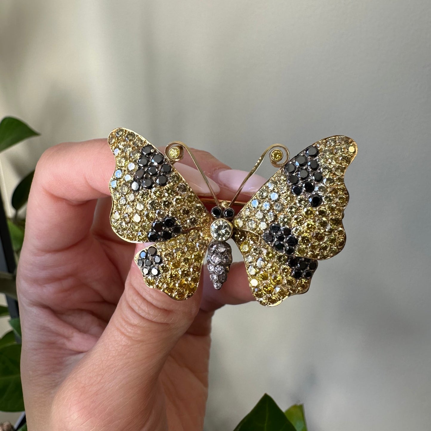1980s 18KT Yellow Gold Yellow, White & Black Diamond Butterfly Brooch in hand